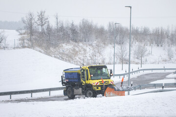 snow plow, winter service on a wet road, winter service truck driving on asphalt road at day while...