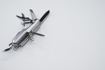 High angle shot of a swiss army knife on a grey surface
