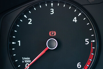 Natural light. the dashboard of the car. The handbrake indicator is on. Close-up.