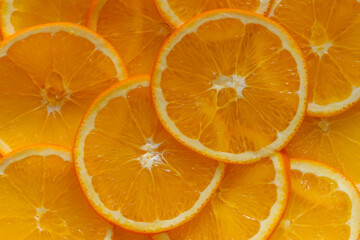 Sliced slices of fresh orange and laid out in the form of background close up. Flat view, healthy food. 