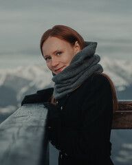 Photoshoot of a happy girl in the mountains in a coat in winter