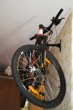 The Bike Is Stored On The Wall On A Holder In The Apartment