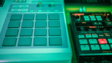 Drum machines in the studio, under colored lights