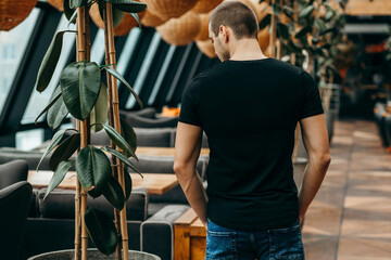 Stylish muscular men wearing black t-shirt, back view