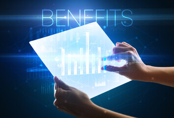 Hand holding futuristic tablet with BENEFITS inscription above, modern business concept