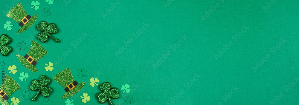 Poster st patricks day shamrock and leprechaun hat corner border. overhead view over a green paper banner b
