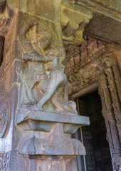 Aihole, Karnataka, India - November 7, 2013: Durga Gudi or Temple. Gray stone love embrace of man and woman placed on pillar of mandapam in front of inner sanctum.