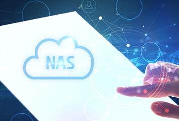 Hand holdig futuristic tablet with NAS inscription, modern technology concept