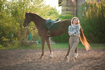 Portrait of girl inplaid shirt with black horse in the horse farm.