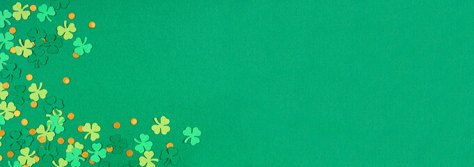 St Patricks Day green background with shamrock and gold coin confetti corner border. Overhead view...