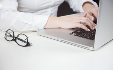 Work from home, e-learning, online learning concept. Close-up, business woman working, hand typing on laptop computer, searching the internet at the table in modern home office. Student studying at ho