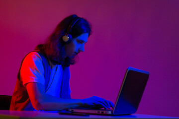 Online programming training, computer programmer or student. A young man with long hair and...