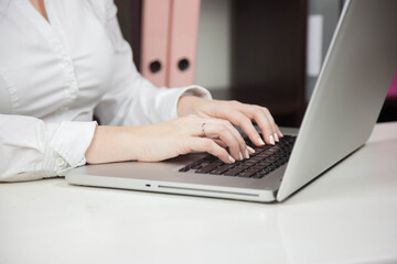 Work from home, e-learning, online learning concept. Close-up, business woman working, hand typing on laptop computer, searching the internet at the table in modern home office. Student studying at ho