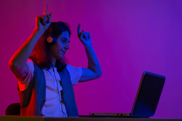 Online programming training, computer programmer or student. A young man with long hair and headphones.