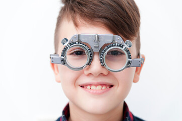 A boy in glasses checks eye vision at ophthalmologist
