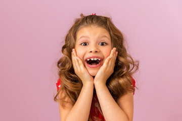 A little girl with curly hair and a red dress is very surprised.