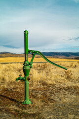 Old hand operated manual well pump in eastern Oregon, USA during an overcast day (vertical orientation)