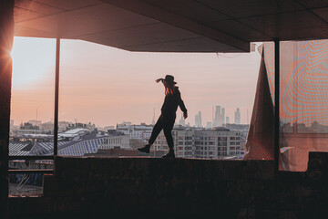 
girl walks along the edge of the balcony