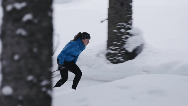Slow motion shot of Professional athlethe cross country skier running on skis trough the frozeen forest covered in snow