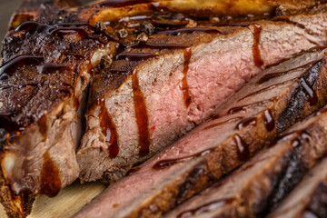 Grilled beef steak, herbs and spices on a dark table. Top view. Free space for your text.