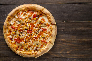 Fresh pizza with tomato sauce, black olives, mozzarella cheese, ham on wooden table closeup. Space for text or copy space. Pizza menu. Restaurant menu advertise