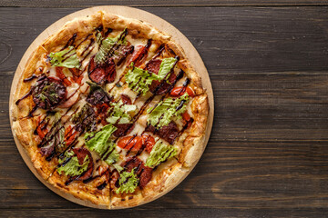 Fresh pizza with tomato sauce, black olives, mozzarella cheese, ham on wooden table closeup. Space for text or copy space. Pizza menu. Restaurant menu advertise