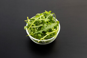 Fresh green rocket salad on dark background.