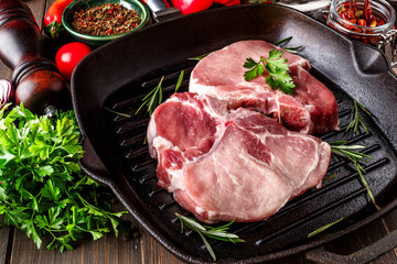 Raw Fresh Meat Steak with Ingredients and Fried Grill Frying Pan.sliced raw pork meat with rosemary.