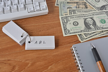 On the desk were bills, a notebook, and a sticky note with the word ABL written on it. It was an abbreviation for the financial term Asset Based Lending.