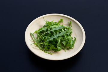 Fresh green rocket salad on dark background.
