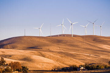 Sunset view of wind turbines on the top of hills in Contra Costa County, East San Francisco bay area, California