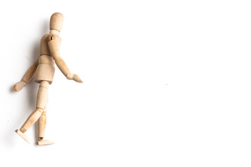 Wooden Mannequin on top of white table as if its walking and standing.