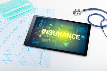 Tablet pc and medical stuff with INSURANCE inscription, prevention concept