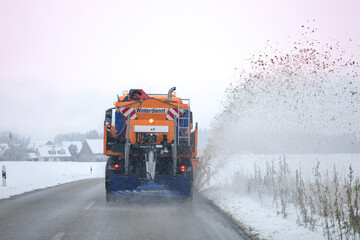 snow plow, winter service on a wet road, winter service truck driving on asphalt road at day while...