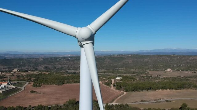 Vistas a&eacute;reas de unos molinos de viento con los pirineos catalanes en el fondo.