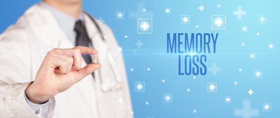 Close-up of a doctor giving a pill with MEMORY LOSS inscription, medical concept