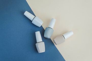 Esmalte de uñas sobre fondo de color, vista superior con espacio para texto, colores crema.