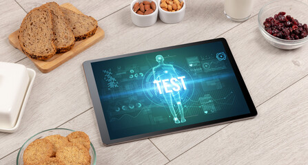 TEST concept in tablet with fruits, top view