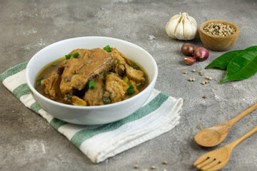 Semur Ayam Tahu, Indonesian traditional food made with chicken, tofu, spices, soy sauce and palm sugar. Grey grainy background, copy space for text. 