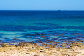 Scenic view of waves rolling in off shore at Ocean Beach Bunbury, Western Australia on a hot summer afternoon creates a splendid seascape with basalt rocks and sandy beaches.