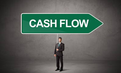 Young business person in casual holding road sign with CASH FLOW inscription, new business direction concept