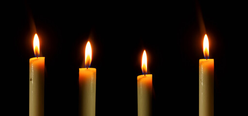 Arranged candles light with different heights burning brightly in the black background, blank and wide background. 