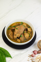 Semur Ayam Tahu, Indonesian traditional food made with chicken, tofu, spices, soy sauce and palm sugar. Marble background, copy space for text. 