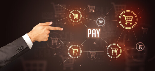 Close-Up of cropped hand pointing at PAY inscription, online shopping concept