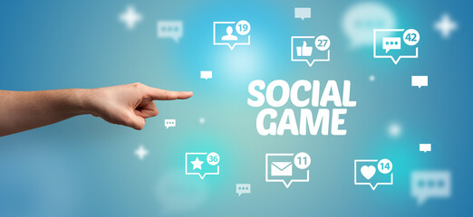 Close-Up of cropped hand pointing at SOCIAL GAME inscription, social networking concept