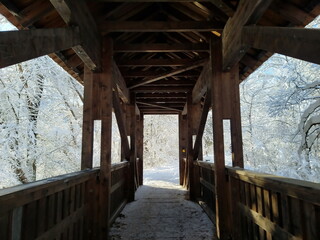 Kleine Holzbrücke in verschneiter Winterlandschaft
