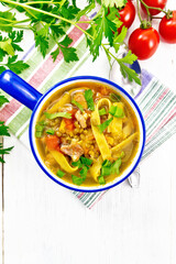 Soup with mung and noodles in blue bowl on light board top
