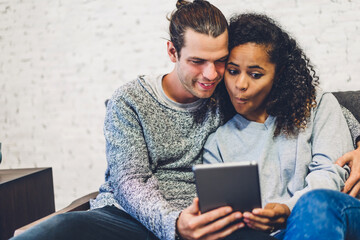 Young couple relaxing and using tablet computer.Couple checking social apps and working.Communication and technology concept