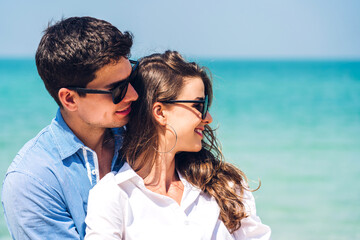 Vacation romantic love young happy couple hug and standing on sand at sea having fun and relaxing together on tropical beach.Summer vacations