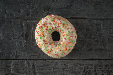 Obraz na płótnie Canvas Top view of a light glazed doughnut on a wooden background.